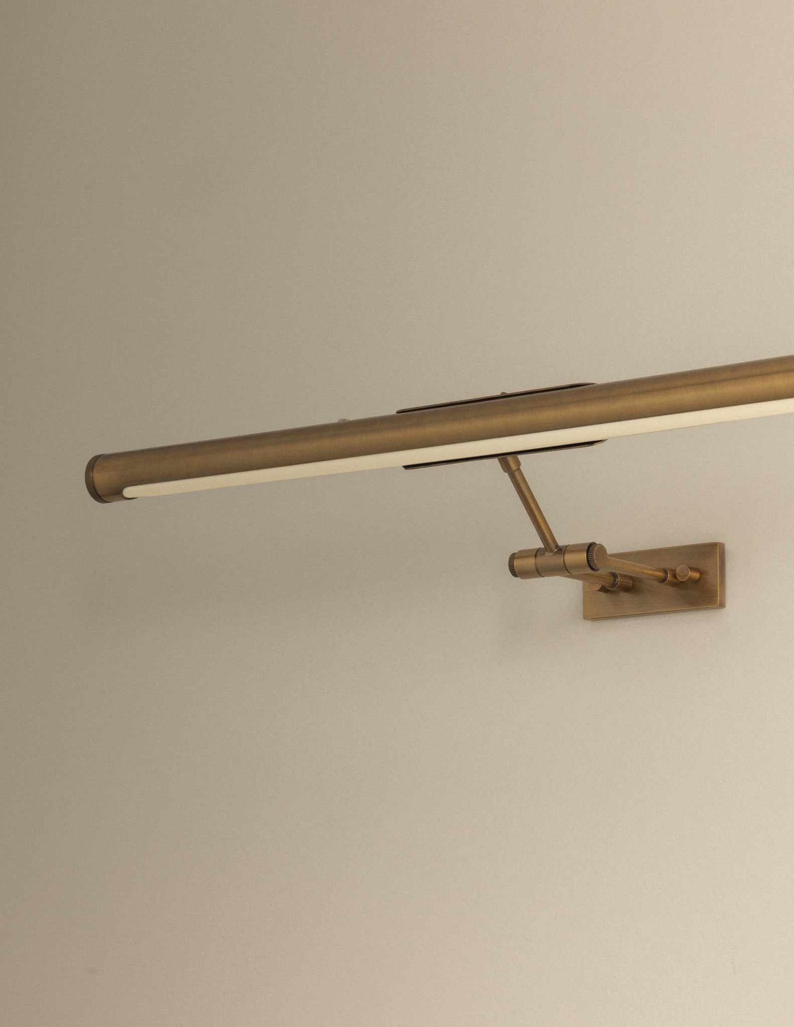 Close-up side view of Kenya Rechargeable Picture Light in Patina Brass showing adjustable double armature and LED diffuser